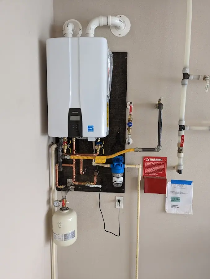 Professional plumber installing copper piping in a Shelburne home